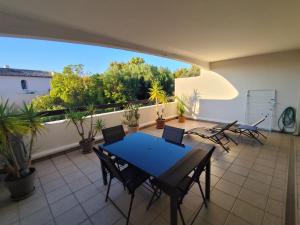 a patio with a table and chairs on a balcony at Résidence L'écume in Saint-Cyprien-Plage