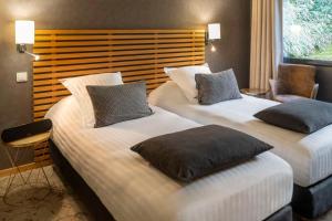 ナントにあるBest Western Plus Hotel De La Regate-Erdreのベッド2台と椅子があるホテルの部屋