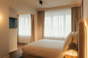 a hotel room with a bed and a large window at Via Antwerp in Antwerp