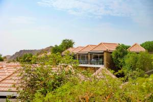 ein Haus mit einer Veranda mit einem Dach in der Unterkunft JA Hatta Fort Hotel in Hatta