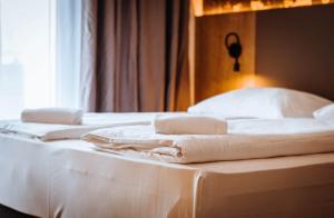 a bed with white sheets and folded towels on it at Hotel Sachsengang - free parking, near U1 & U2 in Groß-Enzersdorf