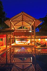 un gran edificio con patio por la noche en Pousada Hibisco, en Trancoso