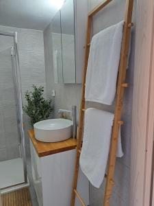 una scala di asciugamani in bagno con lavandino di Downtown Apartment Platanos a Panteli Altre 23 foto