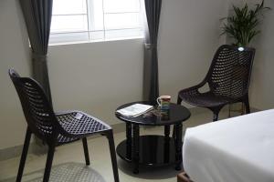 a room with two chairs and a table and a bed at KK Service Suites in Coimbatore