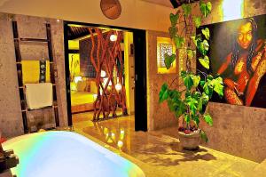 ein Badezimmer mit einer großen Badewanne mit Topfpflanze in der Unterkunft The Zala Villa in Canggu