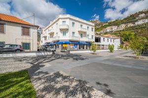 a white building on the side of a street at Reis by KAAMAH in Ribeira Brava