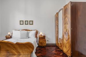 een slaapkamer met een bed en een houten kast bij Reis by KAAMAH in Ribeira Brava