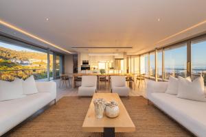 a living room with white couches and a table at Ocean View Villa - Keurboomstrand in Plettenberg Bay