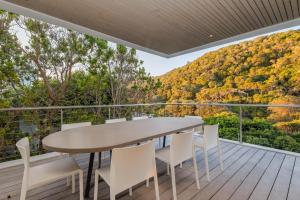 a table and chairs on the deck of a house at Ocean View Villa - Keurboomstrand in Plettenberg Bay