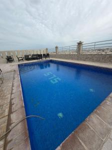 een groot blauw zwembad bovenop een gebouw bij Modern & Elegant Fully Equipped Apartment in Sār