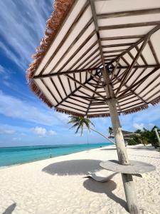een strand met een stoel en een parasol op het strand bij Sosun View Private Villa in Thoddoo