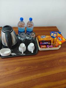 グルヴァイアールにあるSree Nandhanam Nivasのティーポットと水のボトルが置かれたトレイのあるテーブル