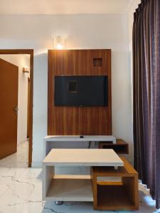 グルヴァイアールにあるSree Nandhanam Nivasのテレビとテーブルのあるリビングルーム