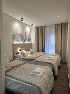 a bedroom with two beds and a painting on the wall at Pension Oasis Alicante in Alicante