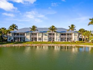 un grande edificio con palme di fronte a un corpo idrico di Positano Vacation Rental a Lely Resort