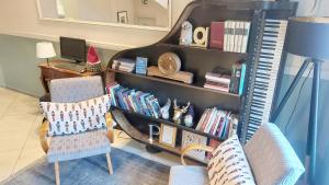 a living room with a book shelf filled with books at Hotel Piano in Szeged