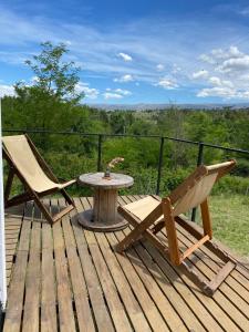 Kururu Cabaña en Villa Yacanto con vista a las sierras في فيلا ياكانتو: طاولة وكراسي على سطح خشبي مع طاولة