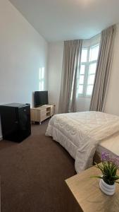 Un dormitorio con una cama y un televisor y una ventana. en SM Room A1, en Abu Dabi