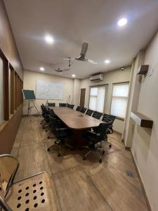 een vergaderzaal met een grote tafel en stoelen bij Hotel LAVENIR in Rohtak