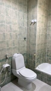 Un baño con inodoro, lavabo y bañera. en SM Room A1, en Abu Dabi