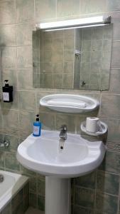 Un baño con un lavabo blanco y un espejo. en SM Room A1, en Abu Dabi
