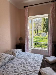 ein Schlafzimmer mit einem Bett und einem großen Fenster in der Unterkunft Pécoule in Bevons