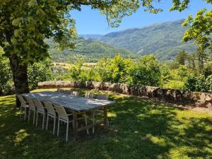 einen Tisch und Stühle im Schatten eines Baumes in der Unterkunft Pécoule in Bevons + 10 Fotos