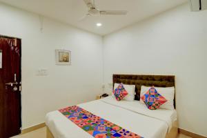 ein Schlafzimmer mit einem großen Bett mit bunten Kissen in der Unterkunft FabHotel Wild Wings Gachibowli in Hyderabad