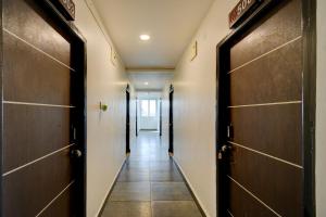 ein Flur mit Holztüren und Fliesenböden in der Unterkunft FabHotel Wild Wings Gachibowli in Hyderabad + 28 Fotos