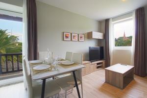 ein Esszimmer mit einem Tisch mit Stühlen und einem Fernseher in der Unterkunft Apartamentos Turísticos La Pontificia in Comillas