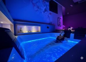 Una mujer sentada en un jacuzzi en una habitación. en Sumaiè Suite - Wellness in Salento, en Mesagne