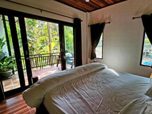 une chambre avec un lit et une grande fenêtre dans l'établissement Baan Phangan, à Ko Pha Ngan 14 autres photos
