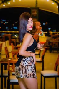 een vrouw staat in een restaurant met een drankje in haar hand bij Hotel Vip70 Jaen Perú in Jaén +8 foto's