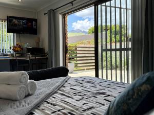 a bedroom with a bed and a sliding glass door at Welcome Home in Somerset West