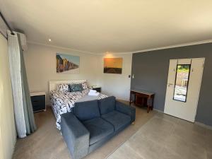 a bedroom with a bed and a couch at Welcome Home in Somerset West