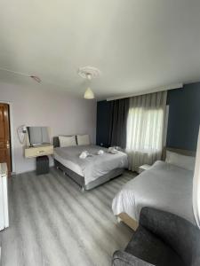 een hotelkamer met twee bedden en een televisie bij Karya Hotel in Kuşadası