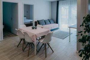 Una sala de estar con una mesa y sillas y un sofá. en Katáng Vendégház, en Tardosbánya