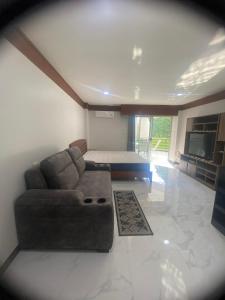 a living room with a couch and a television at Sea Sand Sun Condominium in Ban Bang Nok