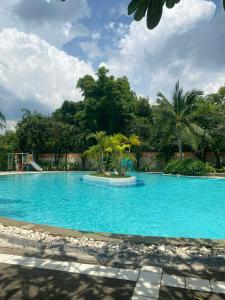 a large blue swimming pool with trees in the background at Sea Sand Sun Condominium in Ban Bang Nok