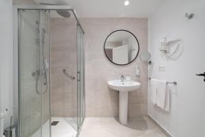a bathroom with a shower and a sink and a mirror at Hotel Arena Castillo in Caleta De Fuste