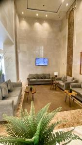 een grote woonkamer met banken en een televisie bij شقق عائلتي - My family's apartments in Jeddah
