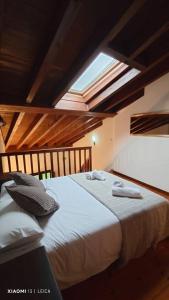una camera da letto con un letto con due asciugamani sopra di La Ayalguina, Selnatur a Mestas de Con