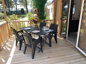 einen schwarzen Tisch und Stühle auf einer Terrasse in der Unterkunft Le Beaupré - prestation hotelière in Mesquer