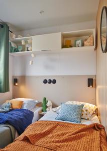 ein Schlafzimmer mit zwei Betten in einem Zimmer in der Unterkunft Le Beaupré - prestation hotelière in Mesquer