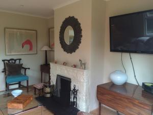 a living room with a fireplace and a flat screen tv at Yew Tree Cottage in Maidford