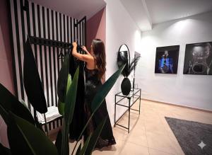 Una mujer parada detrás de una valla en una habitación con una planta. en Sumaiè Suite - Wellness in Salento, en Mesagne