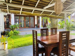 een eetkamer met een houten tafel en stoelen bij Mango House in Dikwella +11 foto's