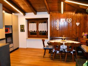 a kitchen and dining room with a table and chairs at Appartamento Caprioli in Pellizzano