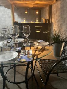 uma mesa de madeira com copos de vinho e cadeiras em Acolhedora casa de 03 quartos em Passos