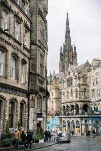 a group of buildings on a city street with a church at 3 Bed Traditional Apartment on Picturesque Victoria St in Edinburgh
